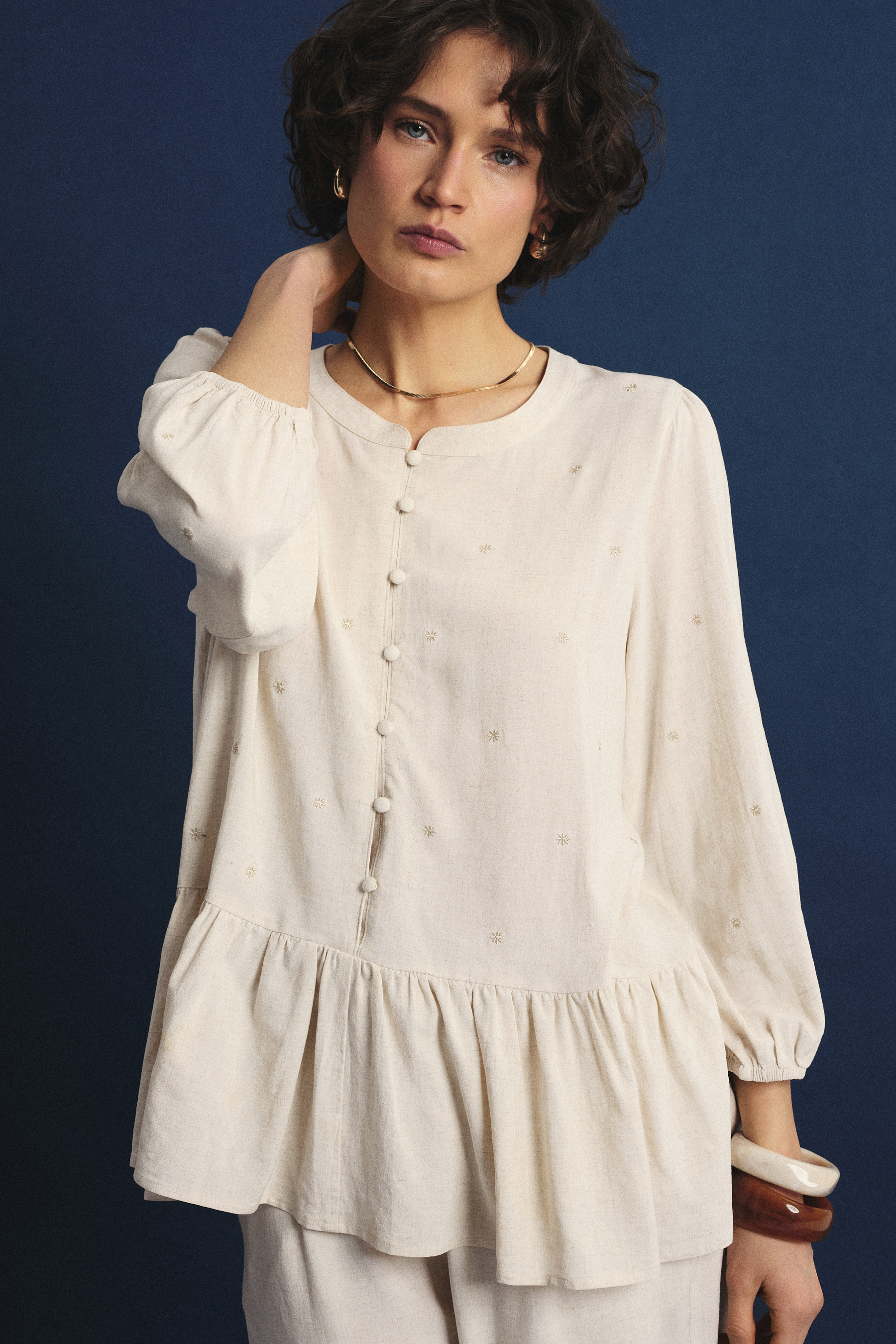 Jasnobeżowa bluzka z ozdobną falbanką u dołu