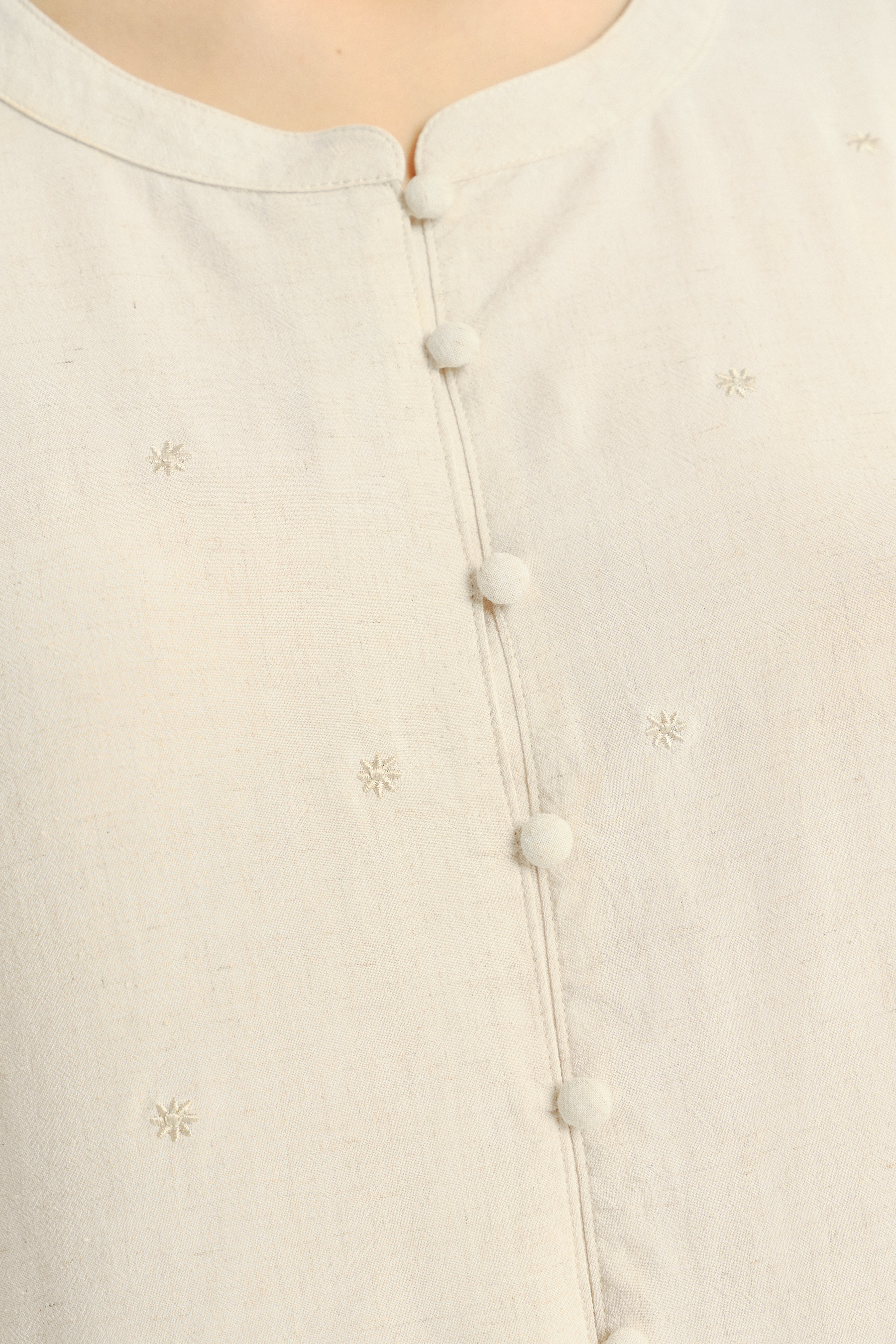 Jasnobeżowa bluzka z ozdobną falbanką u dołu