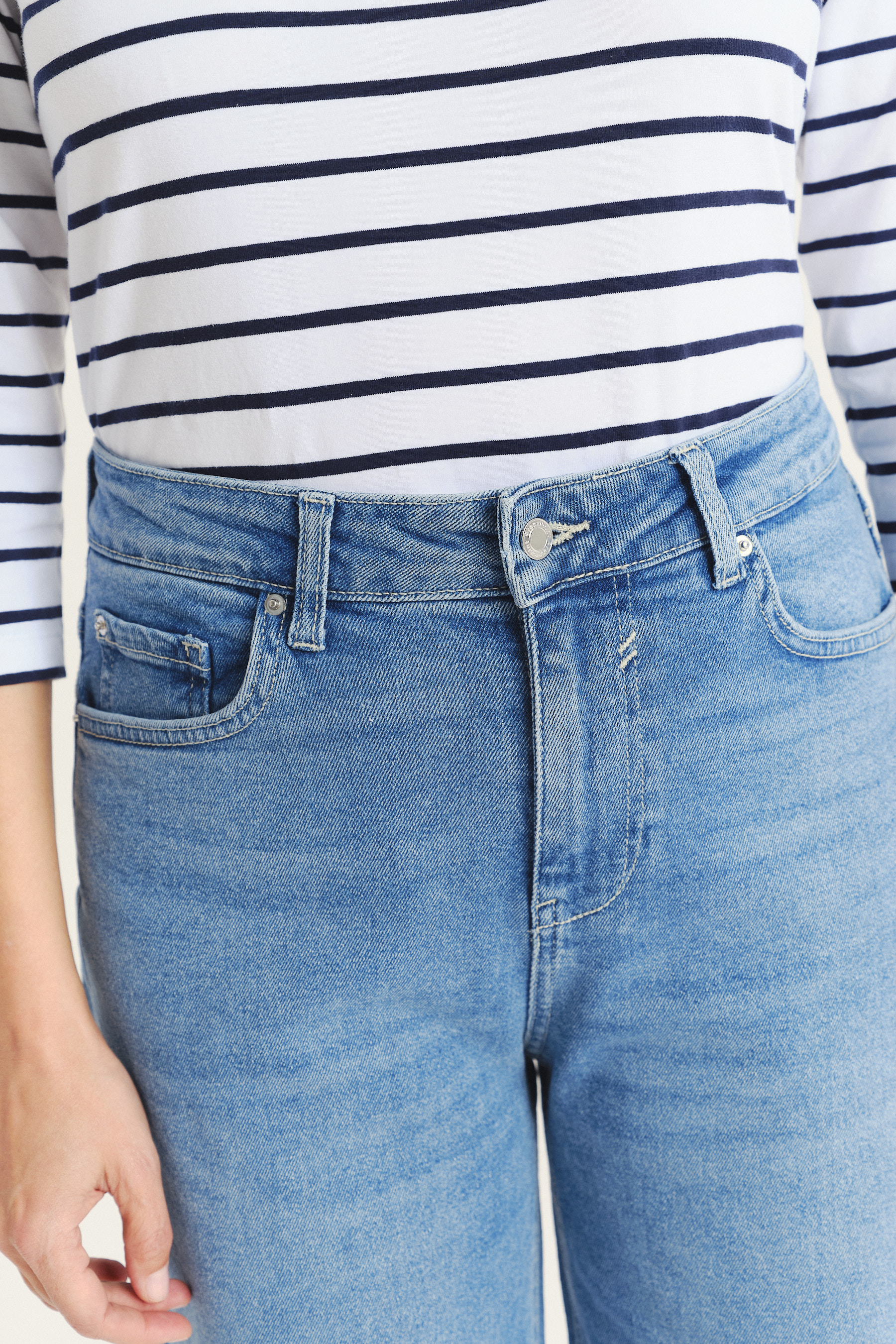 Niebieskie jeansy z podwiniętymi nogawkami