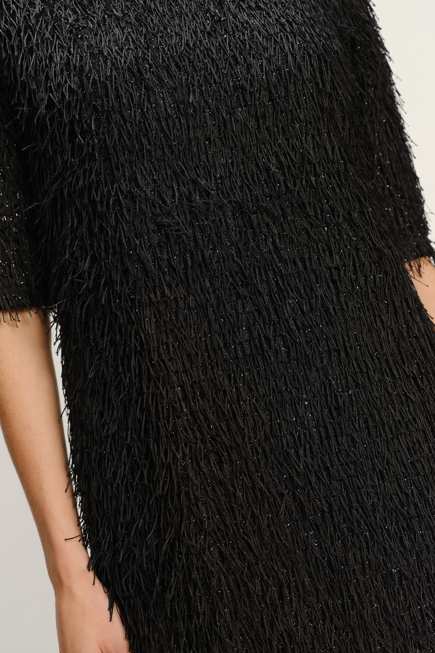 Czarna połyskująca sukienka z efektownym wykończeniem