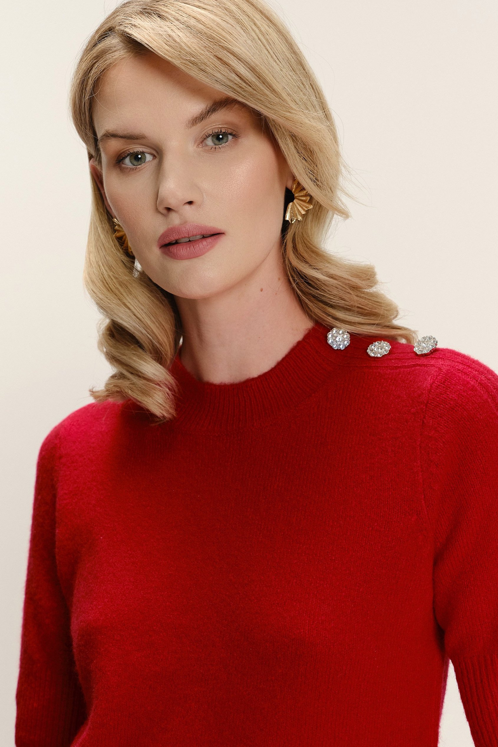 Czerwony sweter z biżuteryjnymi guzikami