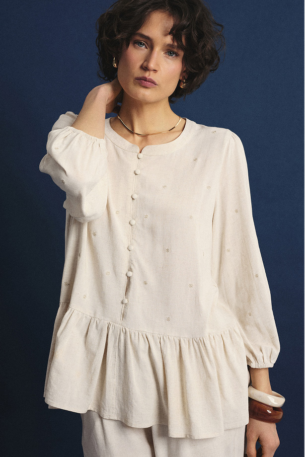 Jasnobeżowa bluzka z ozdobną falbanką u dołu