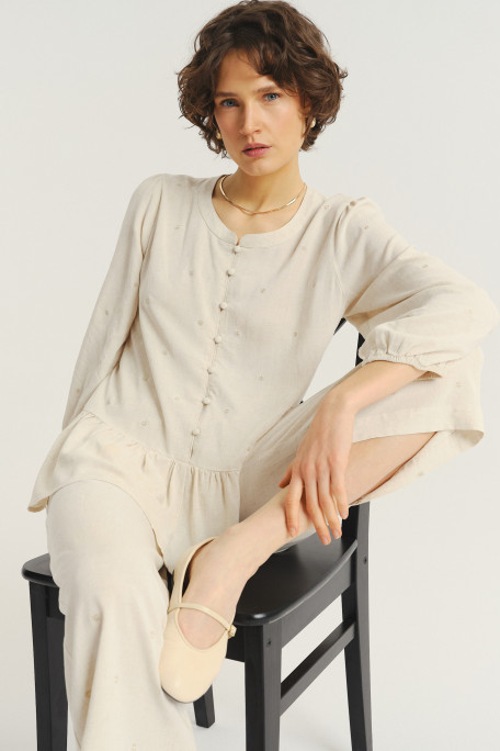 Jasnobeżowa bluzka z ozdobną falbanką u dołu