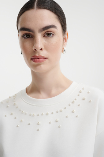Kremowa bluza z dekoracyjnymi perełkami
