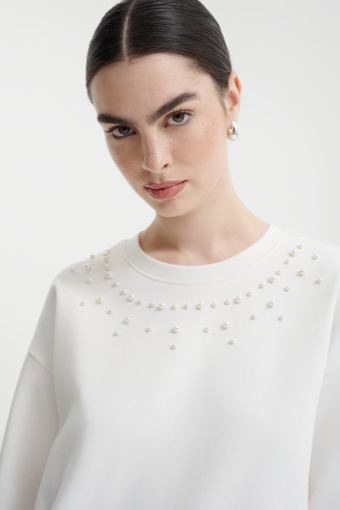 Kremowa bluza z dekoracyjnymi perełkami