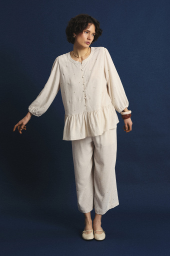 Jasnobeżowa bluzka z ozdobną falbanką u dołu