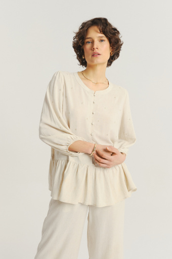 Jasnobeżowa bluzka z ozdobną falbanką u dołu