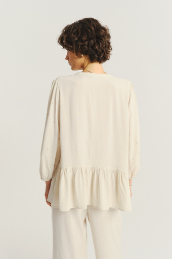 Jasnobeżowa bluzka z ozdobną falbanką u dołu