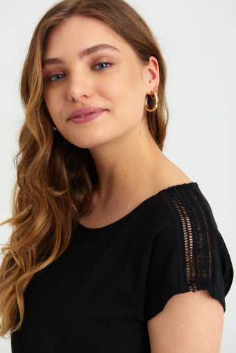 Czarny top z ozdobną, koronkową aplikacją na ramionach